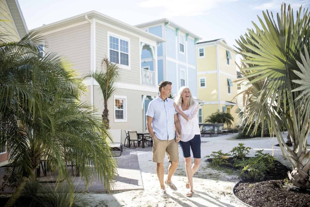 Couple walking across a sandy patio at Margaritaville Cottages Orlando