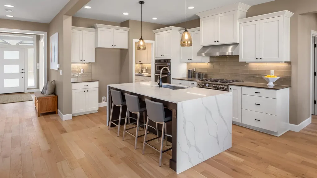 Beautiful kitchen in new luxury home with waterfall island, quartz counter tops, farmhouse sink, and hardwood floors